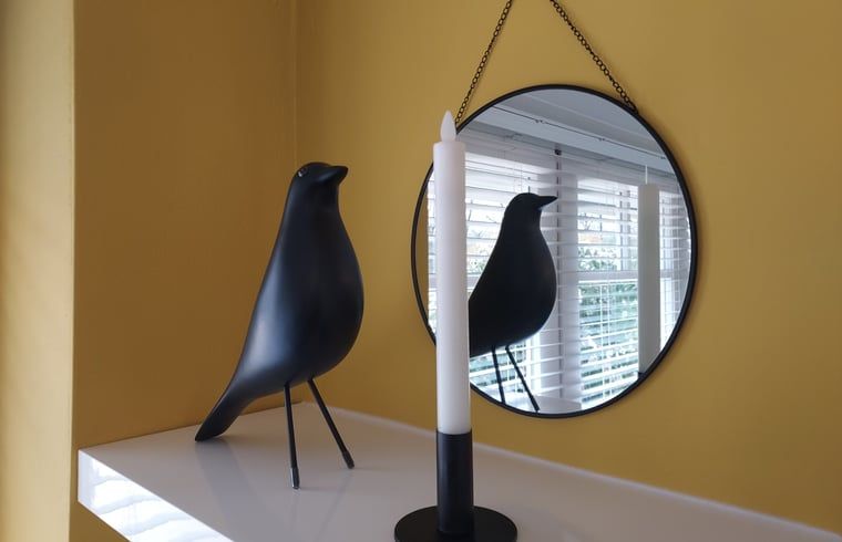 Dekorative Details im Ferienhaus in Heerde, Veluwe, mit Spiegel und Kerze.