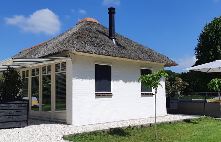 Seitenansicht eines Ferienhauses mit Reetdach in Heerde, Veluwe, Gelderland.