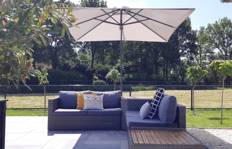 Lounge-Set mit Sonnenschirm auf der Terrasse des Ferienhauses in Heerde, Veluwe, Gelderland.
