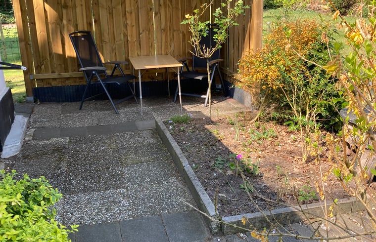 Sonnige Terrasse des Ferienhauses in Hattemerbroek, Veluwe, Gelderland, mit bequemen Sitzgelegenheiten.