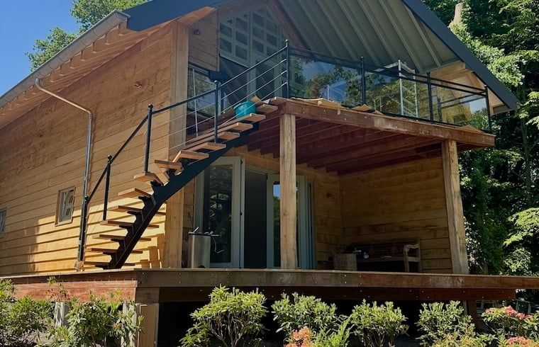 Holzterrasse des Ferienhauses in Hattem mit Blick auf die Veluwe-Waelder in Gelderland.