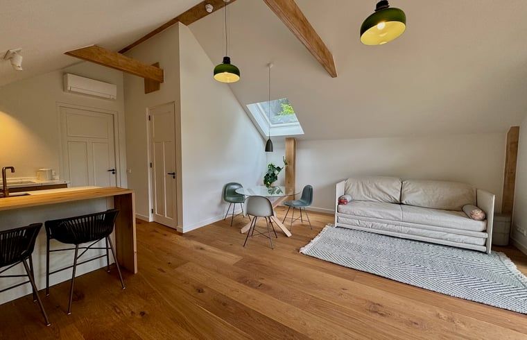 Geraeumiges Wohnzimmer im Ferienhaus in Hattem mit Holzboden und viel natuerlichem Licht, Veluwe, Gelderland.