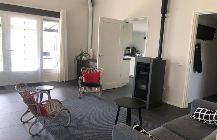 Cozy living room of Huisje in Wapenveld, vacation home on the Veluwe in Gelderland, with modern furnishings and comfortable seating area.