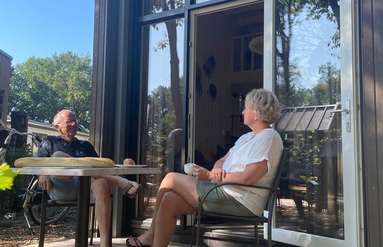 Die Gaeste geniessen ihren Kaffee auf der Veranda des Ferienhauses in Lieren, Veluwe.