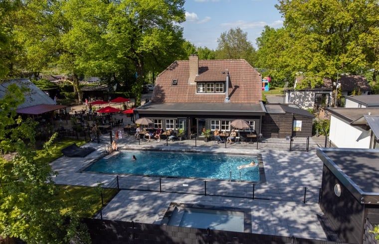 Poolanlage in einem Ferienhaus in Lieren, umgeben von der gruenen Veluwe-Landschaft.