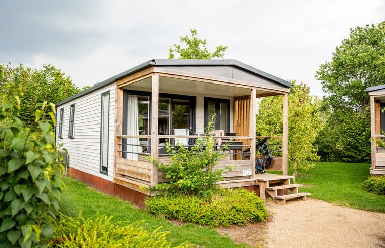 Veranda des Ferienhauses in Lieren, Veluwe, Gelderland mit Blick auf den gruenen Garten.