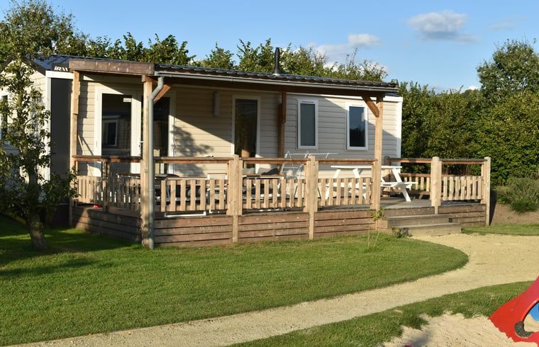 Ferienhaus in Lieren an der Veluwe mit Holzveranda und Blick auf die gruene Umgebung in Gelderland.