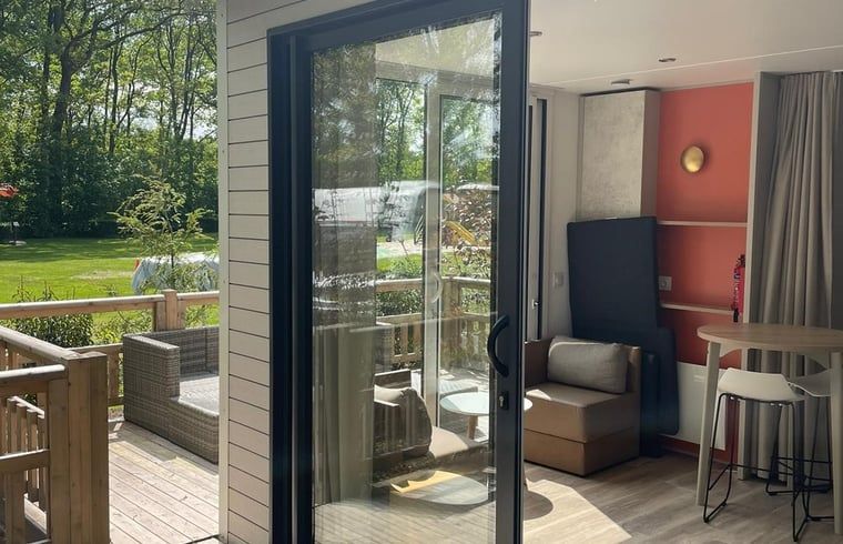 Binnenruimte van Vakantiehuis in Lieren, Veluwe, Gelderland met lichte inrichting en uitzicht op terras.