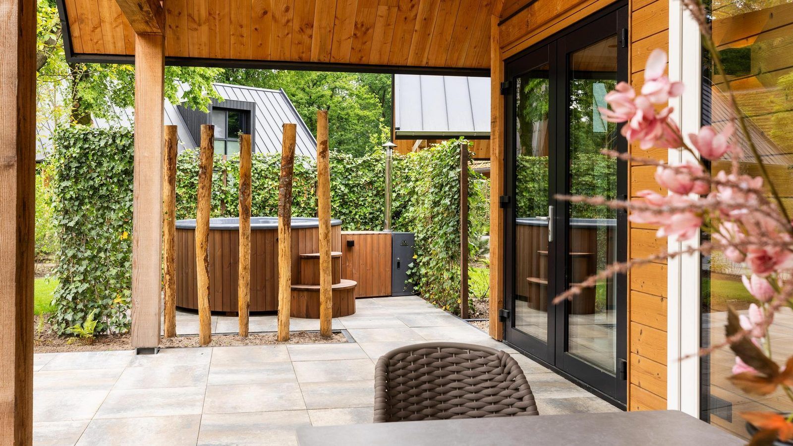 Ueberdachte Terrasse mit Whirlpool in Bos Villa with Hot Tub & Sauna in Wekerom, Veluwe, Gelderland. Ferienhaus fuer sechs Personen.