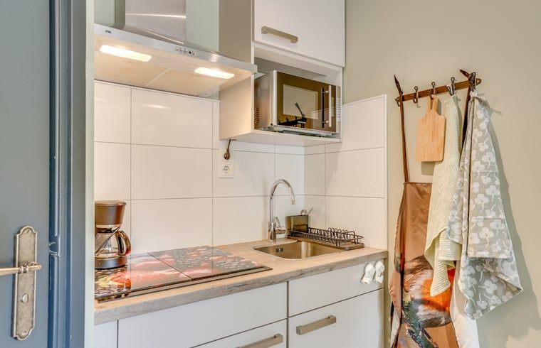 Compacte kitchenette in Huisje in Wekerom, vakantieverblijf op de Veluwe, ideaal voor zelfvoorzienend verblijf.