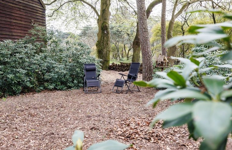 Rustieke zitplek in de tuin van Huisje in Wekerom, vakantiewoning in Gelderland, ideaal voor ontspanning.