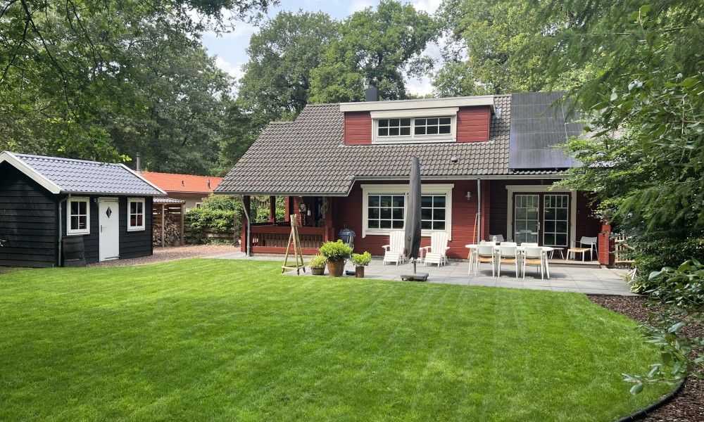 Spacious terrace and green garden at Boshuis Denne, vacation home in Bennekom, Veluwe, Gelderland for relaxation.