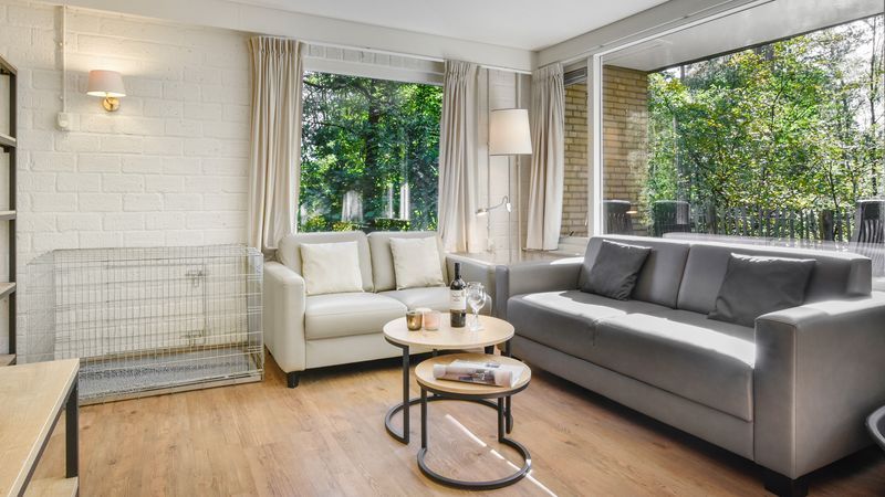 Lichte zithoek met uitzicht op natuur in Coldenhove 6-persoons hondenbungalow in Eerbeek, Veluwe.