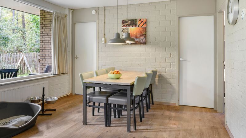 Eetruimte met uitzicht op tuin in Coldenhove 6-persoons hondenbungalow, Eerbeek, Veluwe.