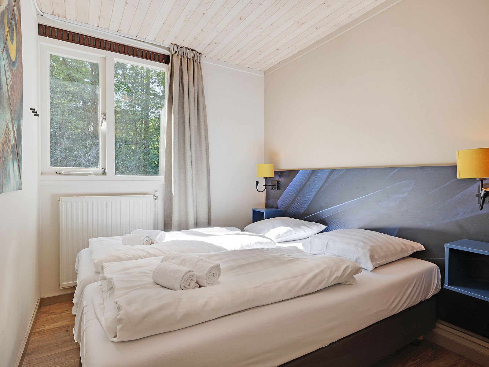 Comfortabele slaapkamer in Rabbit Hill 8-persoons bungalow 8C, Nieuw Milligen, Veluwe, met tweepersoonsbed en natuurlijk licht.