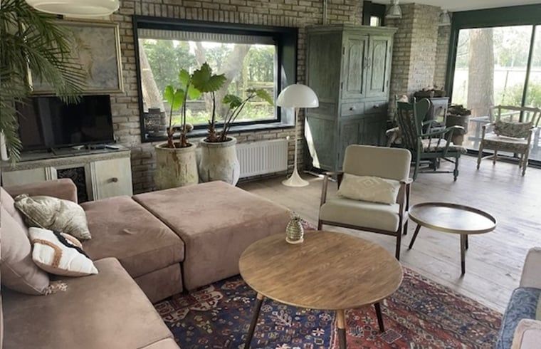 Gemuetliches Wohnzimmer im Ferienhaus in Nijkerk, Veluwe, mit rustikalen Moebeln.