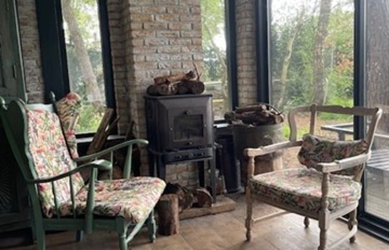 Gemuetliche Sitzecke mit Holzofen im Ferienhaus in Nijkerk, Gelderland.