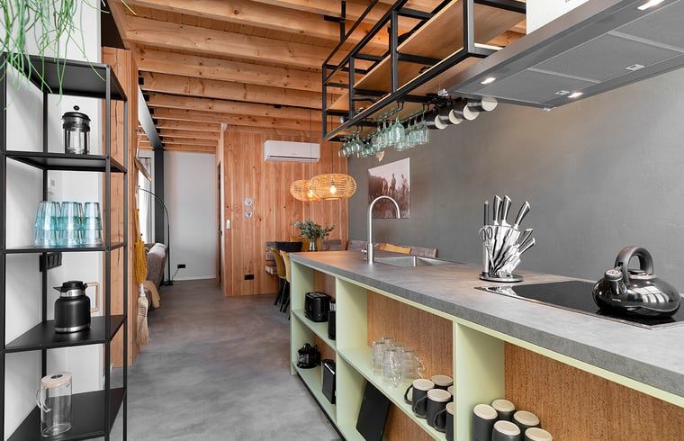 Moderne keuken in Huisje in Veessen, vakantiehuis op de Veluwe, met open planken en strakke inrichting.