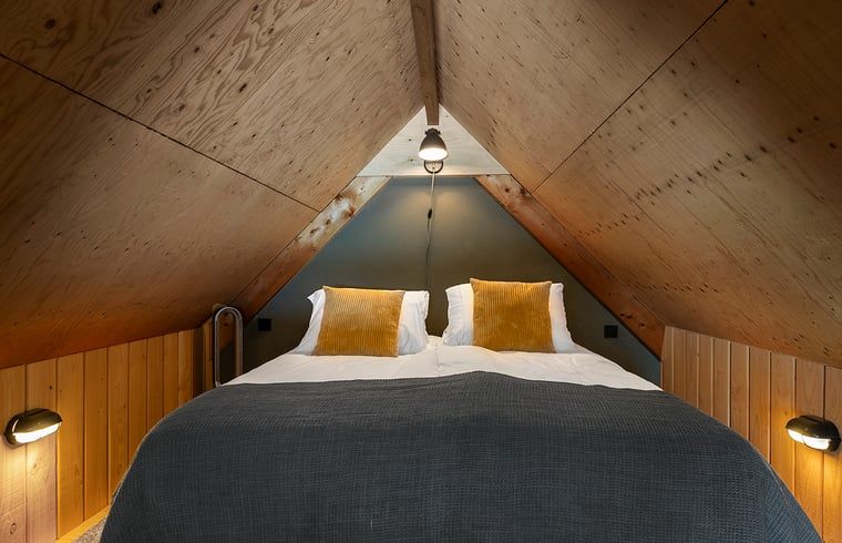 Gezellige zolderkamer in Huisje in Veessen, Veluwe, met houten interieur en comfortabele bedden.