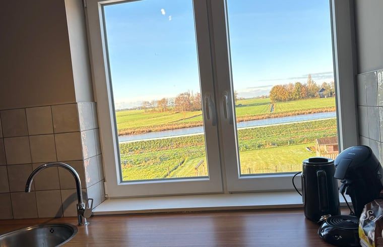 View from the kitchen of Holiday Home in Schildwolde, Groningen, with wide fields and a river in northeastern Groningen.