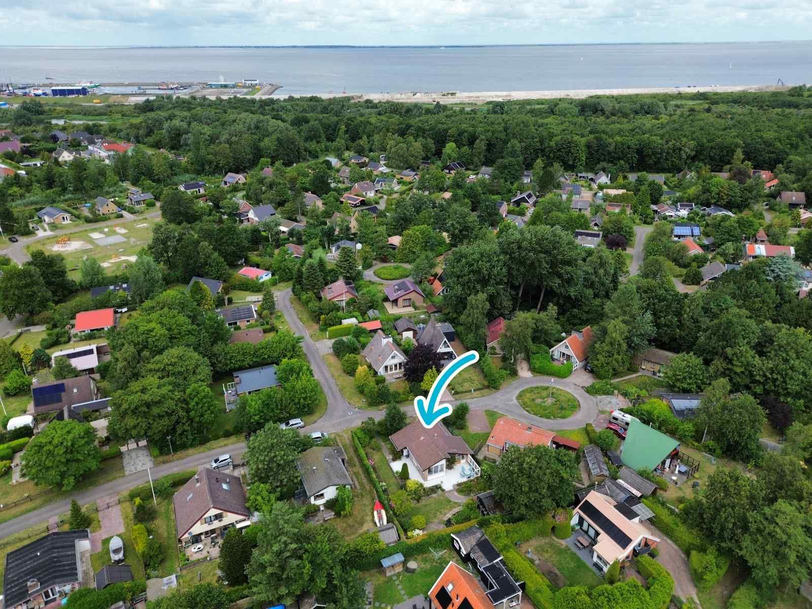 Eethoek in GR032 vakantiewoning, Lauwersoog, met schilderij en houten meubels.