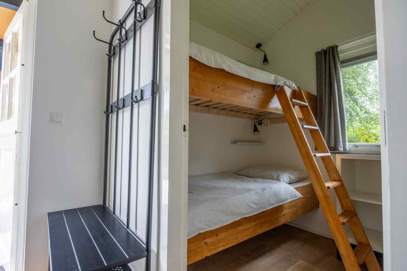 Lichte woonkamer met hoekbank in GR032 vakantiehuis, Lauwersoog, Groningen.