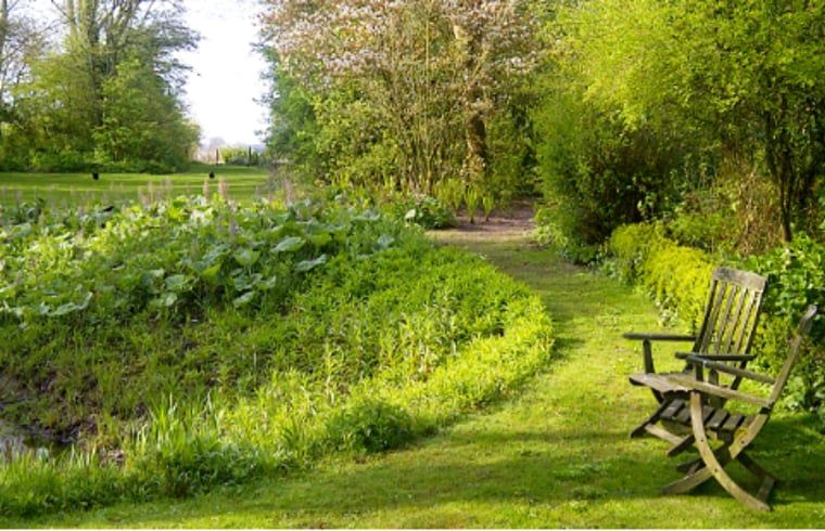 Prachtige tuin bij Vakantiehuisje in Molenrij, met een uitnodigend wandelpad in Groningen.