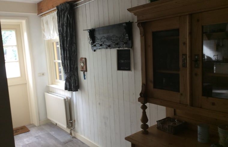 Gemuetlicher Innenbereich des Huisje in Ter Apel, Ferienhaus im Suedosten von Groningen, mit bequemen Sitzgelegenheiten und rustikaler Einrichtung.