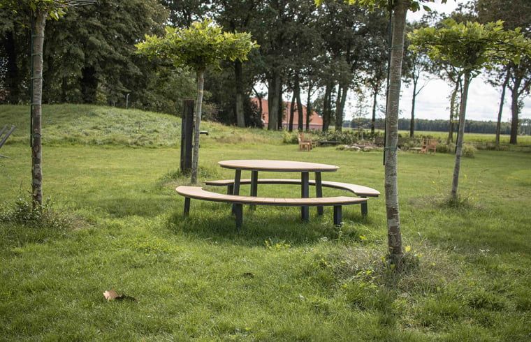 Runder Picknicktisch im Garten des Ferienhauses Cottage in Bourtange, umgeben von Gruen in Groningen.