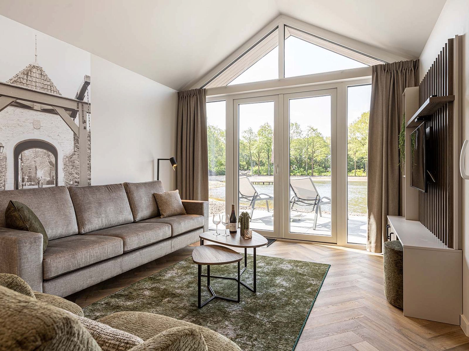 Cozy living room of the detached house in Sellingen, Groningen, with views of nature through large windows and a comfortable seating area.