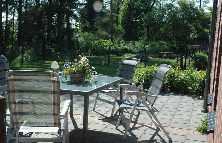Huisje in Zevenhuizen, zonnig terras met tuinstoelen in Zuidwest Groningen, Groningen.