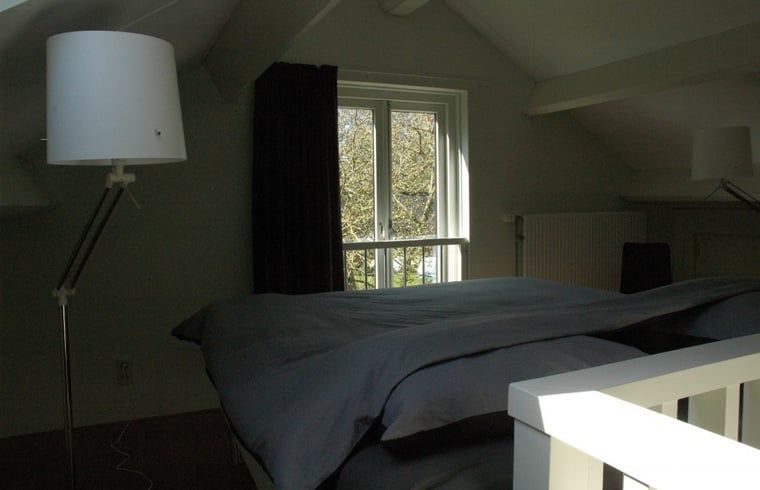 Huisje in Zevenhuizen, slaapkamer met groot bed en raam in Zuidwest Groningen, Groningen.