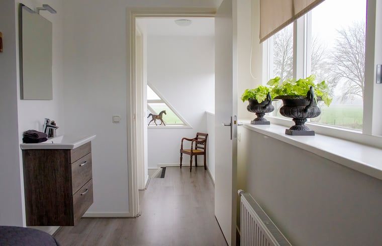 Gang met uitzicht in Huisje in Marum, vakantiehuis in Zuidwest Groningen met natuurlijke lichtinval.