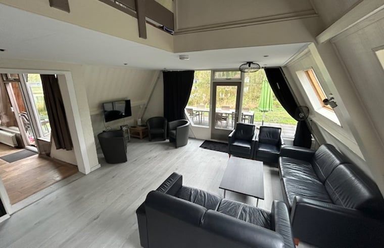 Spacious living room of Holiday Home in Stramproy, located in Central Limburg, with comfortable seating area and views of the green surroundings.