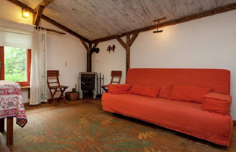 Gezellige woonkamer in Huisje in Leudal, vakantiehuis in Midden Limburg. Warme inrichting met houtkachel en comfortabele zitruimte.