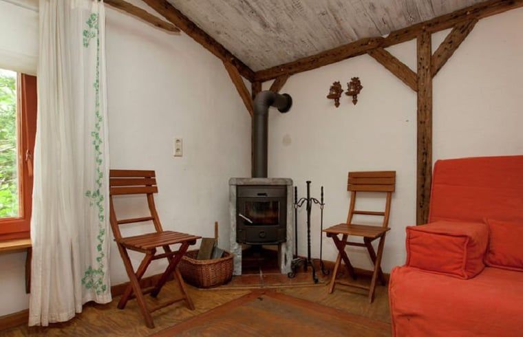 Gezellige zithoek met houtkachel in Huisje in Leudal, een charmant vakantiehuis in het hart van Midden Limburg, omringd door rustieke details.