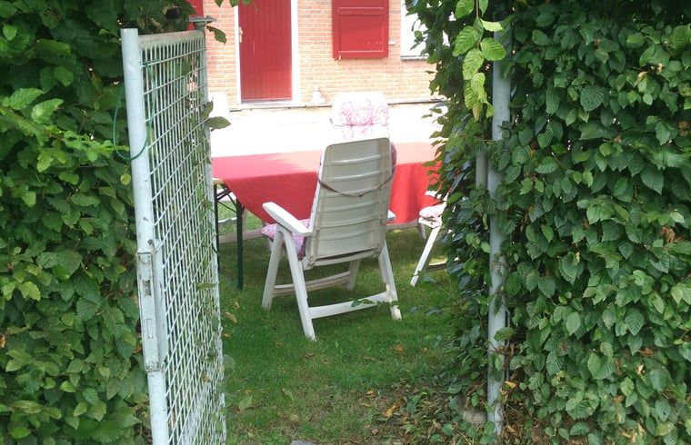 Tor zum Ferienhaus in Susteren, Limburg, umgeben von ueppiger Natur.