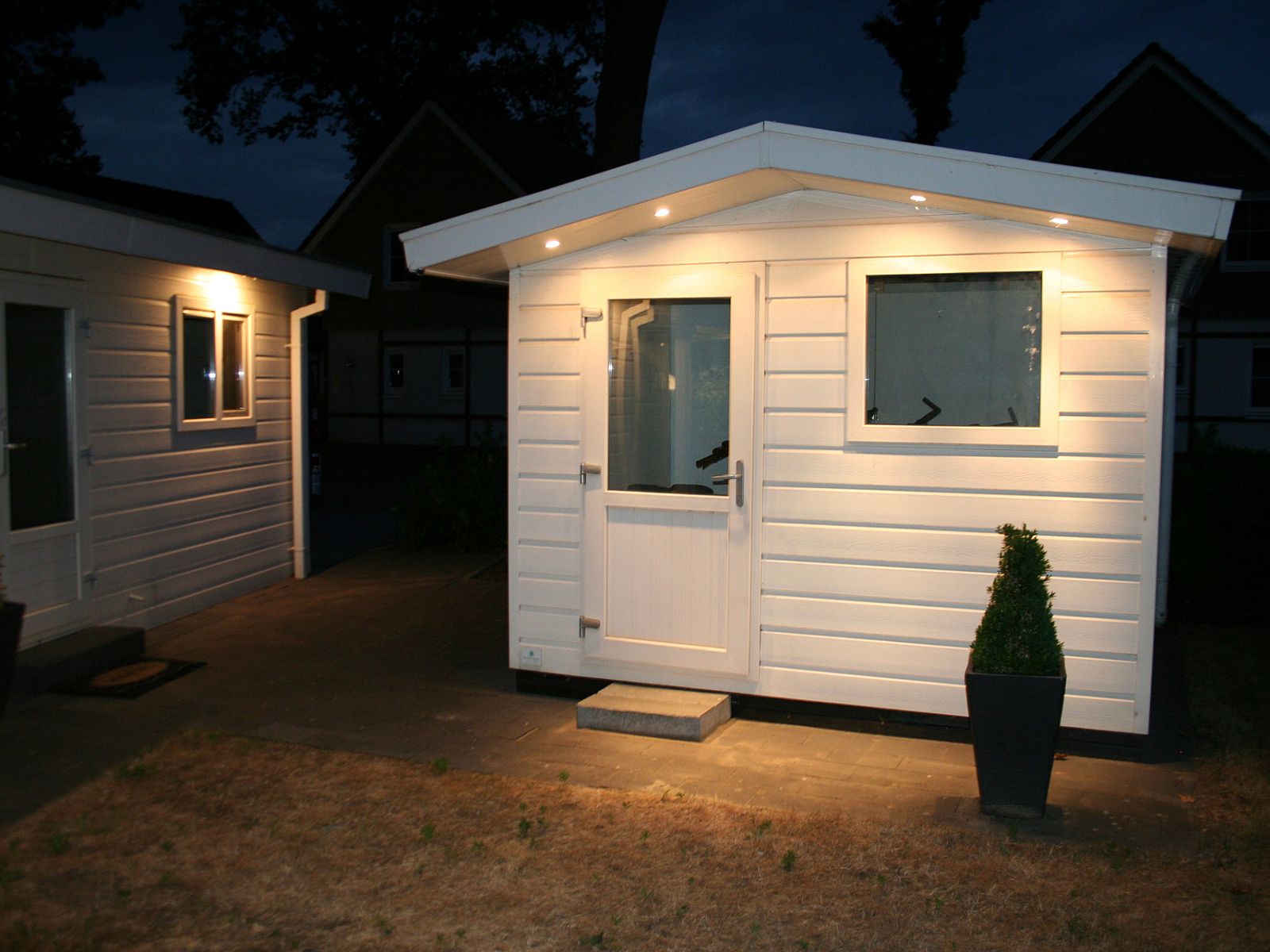 Der beleuchtete Eingang des Chalets in Susteren, Zentral-Limburg, Limburg, strahlt Gastfreundschaft aus.