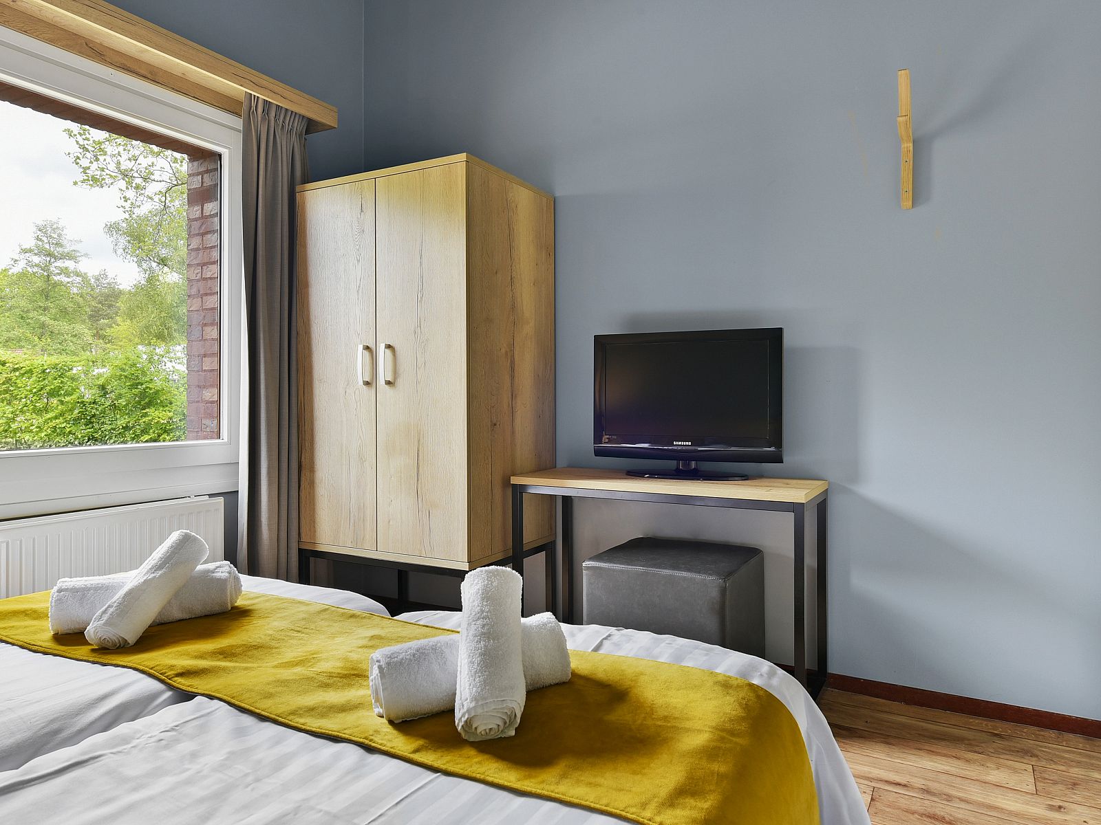 Slaapkamer in Landgoed Aerwinkel 4-persoons bungalow 4BL, Posterholt, Limburg, met tweepersoonsbed en uitzicht op de tuin.