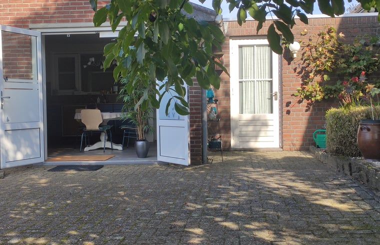 Gemuetliche Terrasse im Haus in Kelpen-Oler, einem Ferienhaus im Zentrum von Limburg, mit offenen Tueren zum Innenraum und zur gruenen Umgebung.