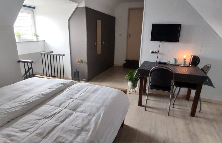 Gemuetliches Schlafzimmer im Ferienhaus in Kelpen-Oler, Mittellimburg, mit bequemem Bett und Arbeitsbereich, ideal fuer einen entspannten Urlaub.