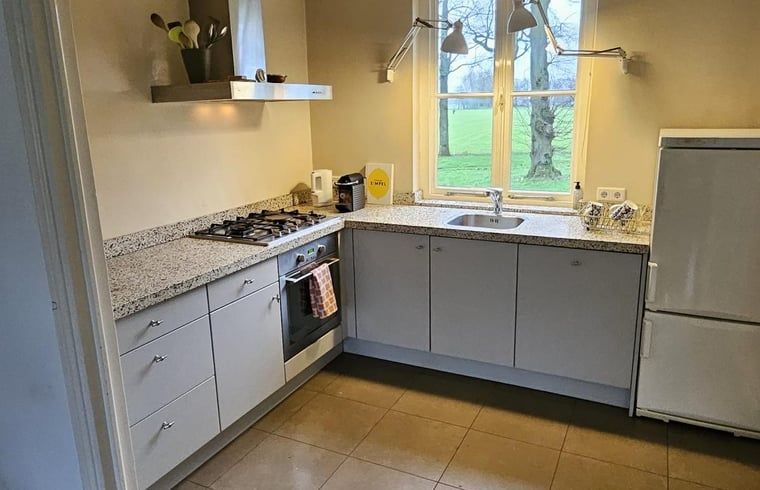 Moderne Kueche im Ferienhaus Cottage in Geijsteren, Nord-Limburg, mit Blick auf gruene Felder.