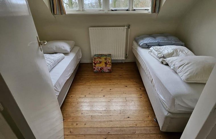 Zweites Schlafzimmer im Ferienhaus in Geijsteren, Nord-Limburg, mit zwei Einzelbetten und Holzboden.