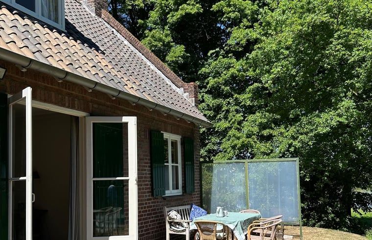 Sonnige Terrasse am Ferienhaus in Geijsteren, Nord-Limburg, mit bequemen Sitzgelegenheiten und gruener Umgebung.