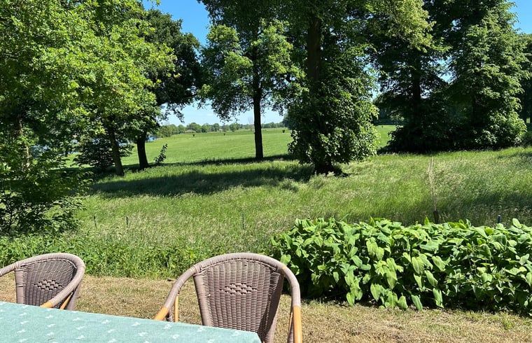 Blick von der Terrasse des Ferienhauses in Geijsteren, Nord-Limburg, auf saftig gruene Felder.