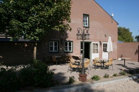 Terras bij Appartement Groen, Blauw of Rood in Horst, Noord Limburg met gezellige zitjes en schaduwrijke bomen.