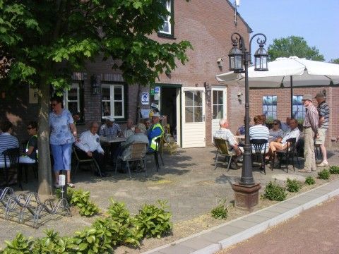 Gezellig terras met parasols bij Appartement Groen, Blauw of Rood in Horst, Noord Limburg, perfect voor ontspanning.