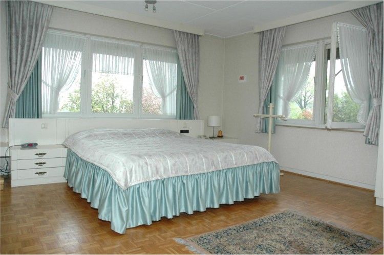 Gerumiges Schlafzimmer mit groem Bett in der Ferienvilla Hubertushof, Horst, Nord-Limburg, mit viel Tageslicht und eleganten Vorhngen.