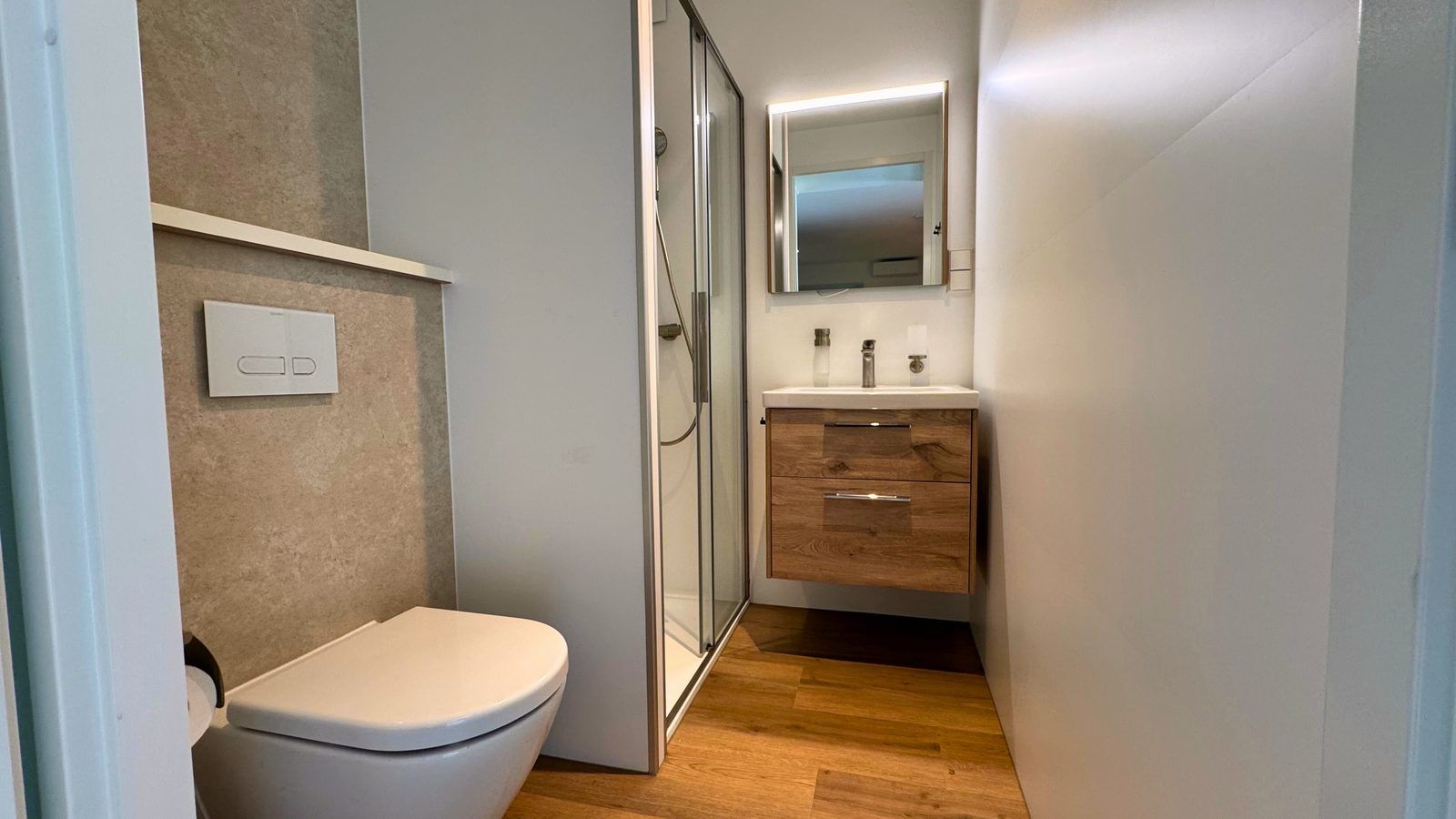 Moderne badkamer in Bos Lodge, vakantiehuis voor 8 personen in Maasbree, Noord Limburg. Stijlvolle inrichting met douche en houten accenten.