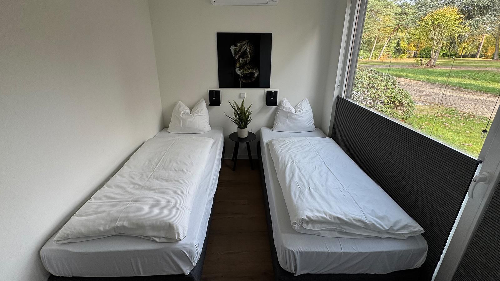 Sfeervolle slaapkamer in Bos Lodge voor 8 personen, vakantiehuis in Maasbree, Noord Limburg, met uitzicht op de groene natuur.